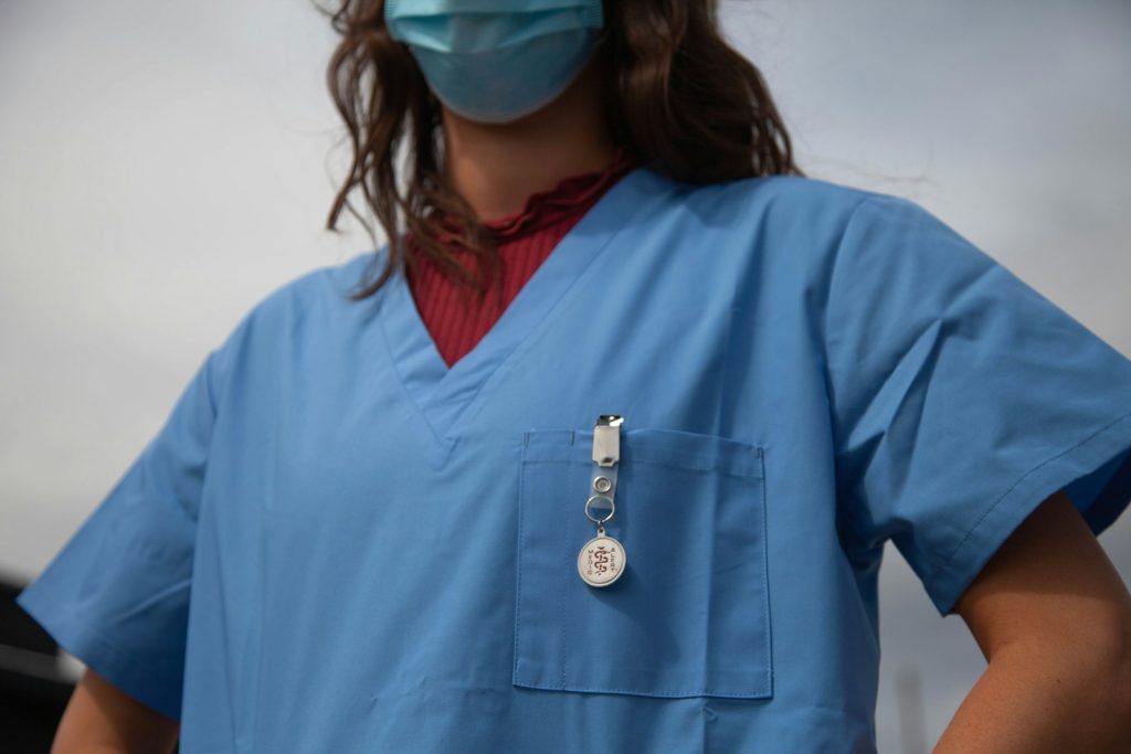 Healthcare worker in scrubs and goggles
