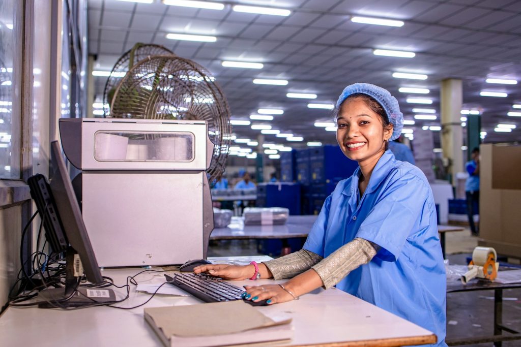 Asian woman at a computer in a factory