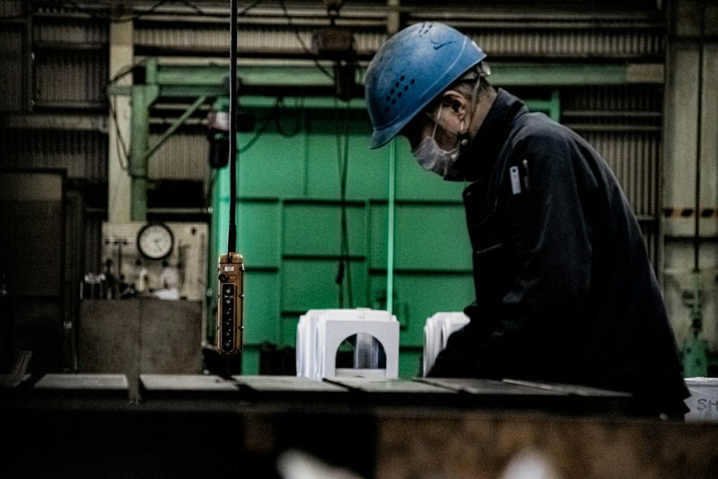 Asian welder, blue cap, workshop