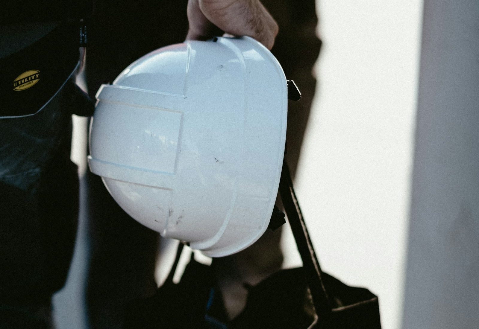 Hand holding a white hard hat
