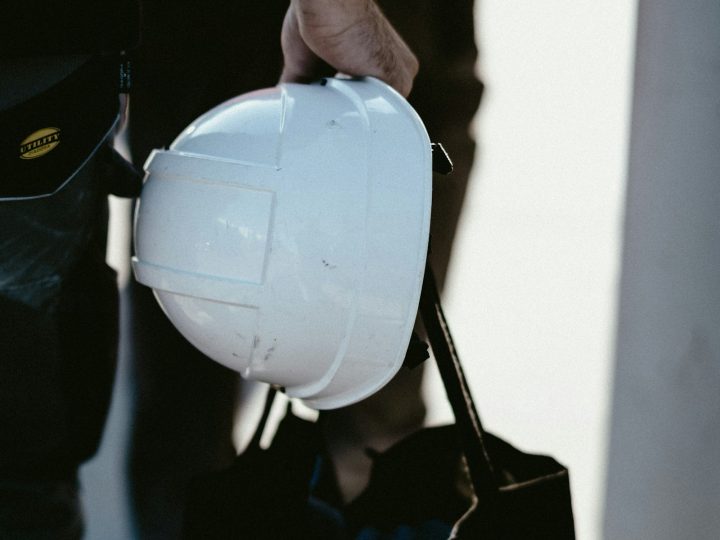 Hand holding a white hard hat